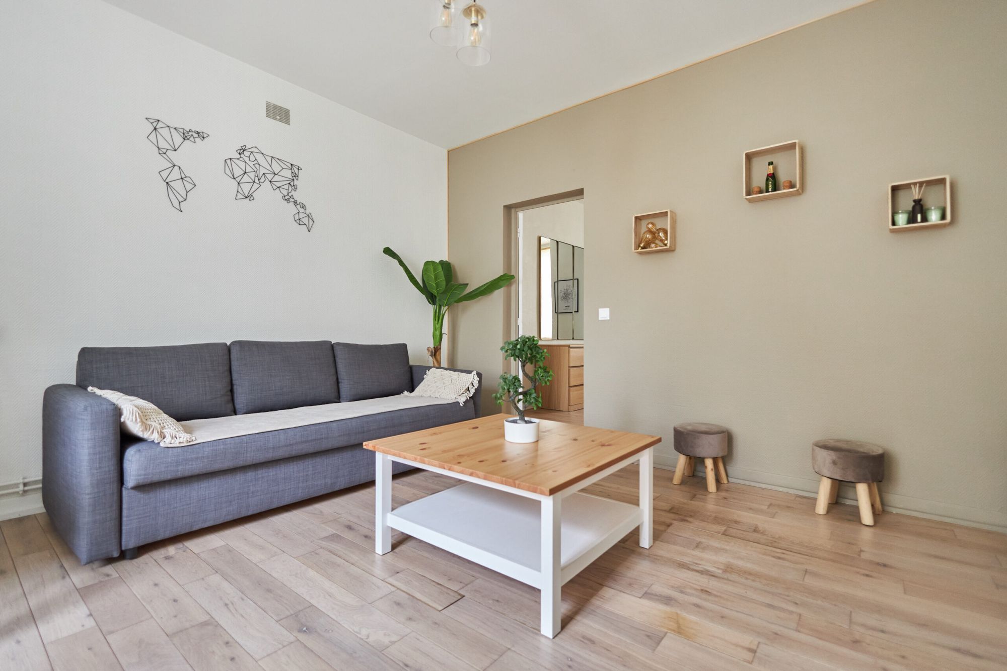 Salon lumineux avec canapé gris et décoration contemporaine photographié pour une annonce immobilière
