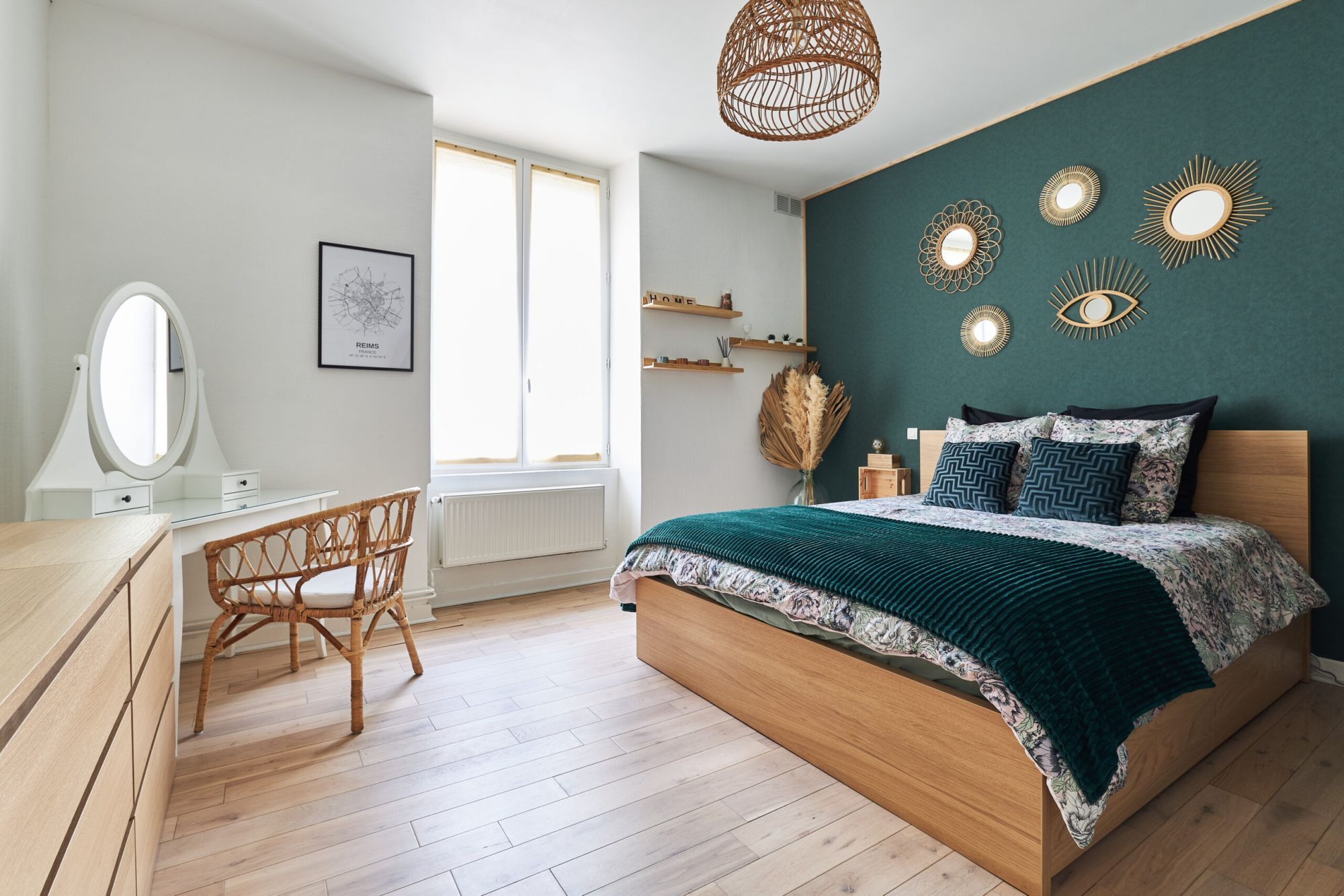 Chambre avec lit double et mur bleu canard dans un appartement Airbnb