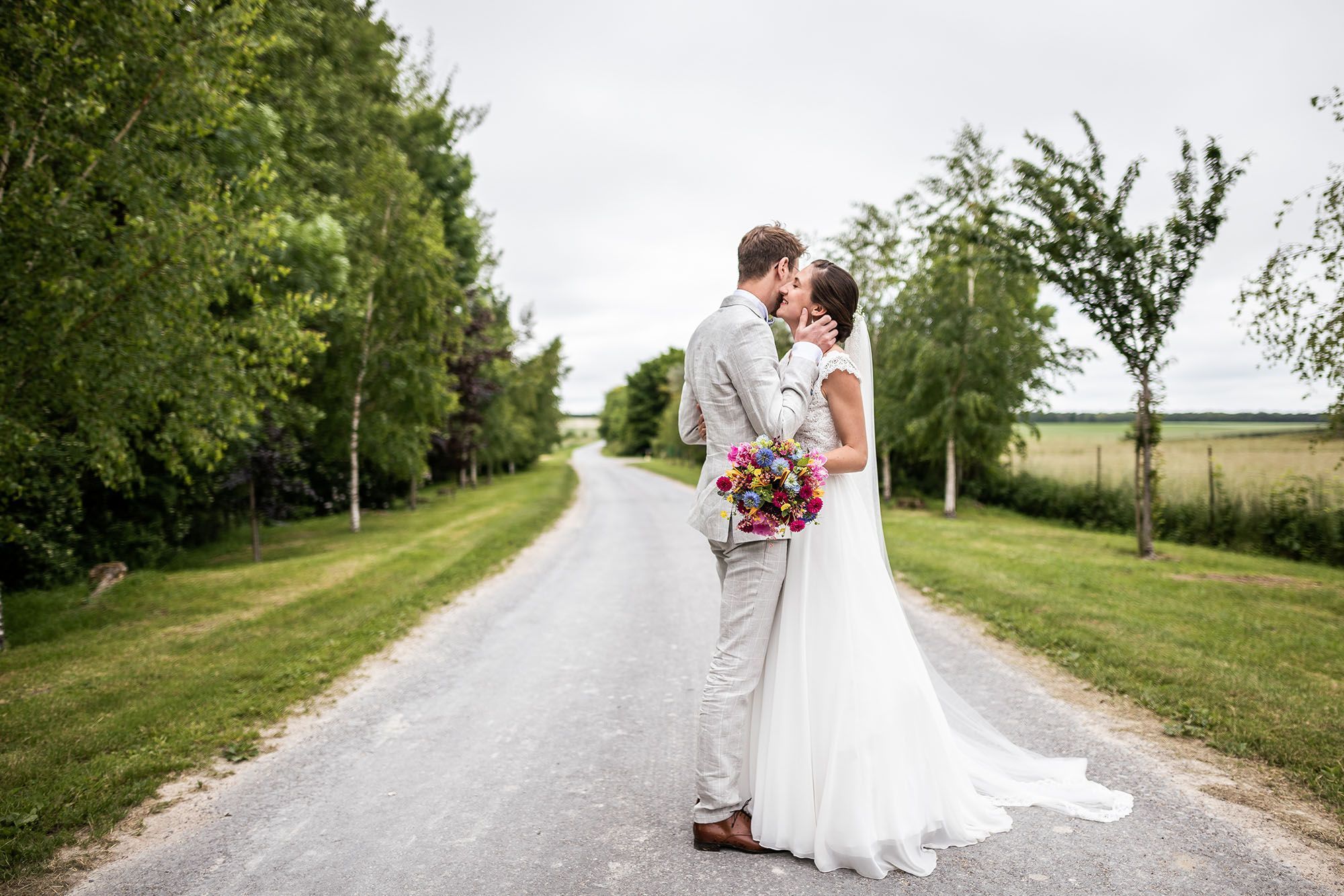 Mariés qui s’embrassent sur un chemin de campagne lors d’un reportage de mariage à Reims